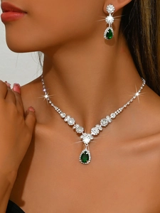 Close-up of bridal jewelry set with emerald water drop crystals on a model
