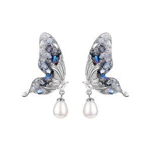 Silver butterfly earrings with blue crystals and teardrop pearls on a white background