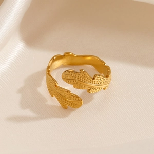Minimalist gold leaf shaped open adjustable stainless steel ring on silk background