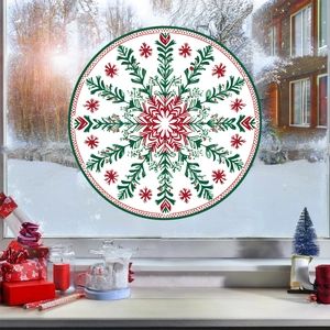 Close-up of snowflake mandala window cling with Christmas gifts and candle decoration