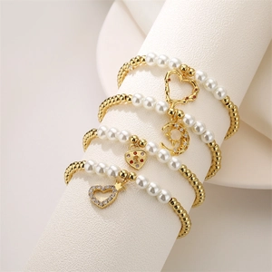 Juego de cuatro pulseras de cuentas doradas con colgantes de corazón, luna y estrella