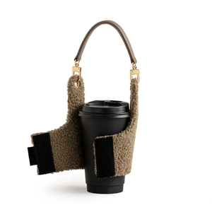 Brown fleece coffee cup sleeve with leather handle and golden buckles on white background