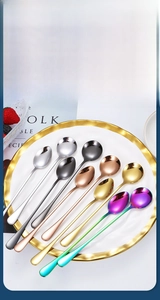 Detailed macro of assorted colorful long-handled stainless steel round dessert spoons