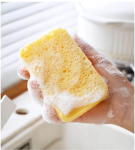 Macro shot of yellow wood pulp sponge creating rich foam for kitchen dishwashing