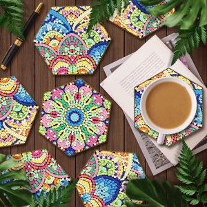 Set of six hexagonal mandala diamond painting coasters on a dark wood background