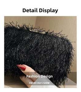 Close-up of elegant black feather fringe evening clutch bag with golden metal clasp detail