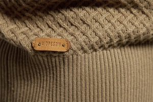 Close-up of khaki waffle knit texture and ribbed cuff on cotton crewneck sweater
