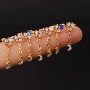 Detailed close-up of gold moon and star pendant earrings with colorful zircon stones