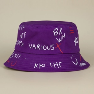 Detail view of purple bucket hat showing white hand-painted graffiti letter prints