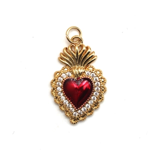 Detailed close-up of a golden heart pendant with red enamel and sparkling zircons