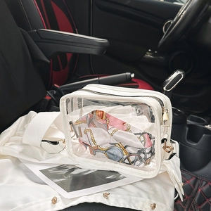 Detail of transparent PVC crossbody bag with white leather trim and silk scarf inside