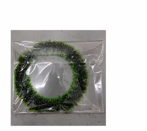 Close-up of a green and red Christmas wreath with bow in clear plastic packaging