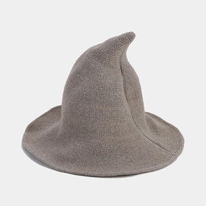 Detail of taupe knitted witch hat showing tight yarn texture and curved pointed tip