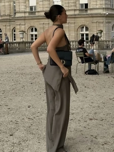 Minimalist halter neck top and loose wide-leg trousers set in dark brown outdoor view