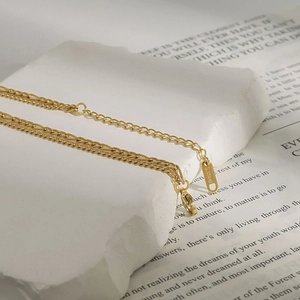 Detail of layered gold stainless steel necklace with S.Steel tag and lobster clasp