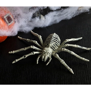 Realistic white skeleton spider decoration for Halloween on dark wood table