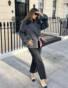 Détail d'un manteau en laine gris foncé avec col en fourrure et poignets duveteux