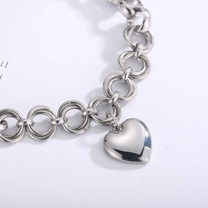 Macro shot of silver heart pendant on a polished interlocking loop chain necklace