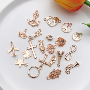 Macro shot of rose gold alloy charms including airplane anchor and star shapes on a plate