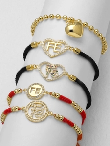 Makro-Detail eines 5-teiligen religiösen Armbandsets mit goldenem Herz und FE-Anhängern
