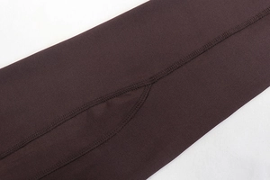 Detailed close-up of dark brown high-elastic fabric with precision flatlock stitching