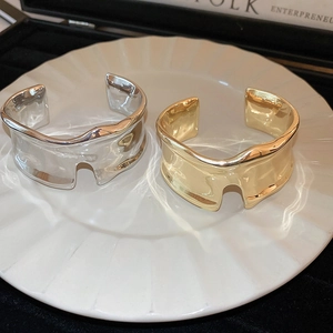 Minimalist wide irregular wave pattern open cuff bracelet in polished gold and silver finishes