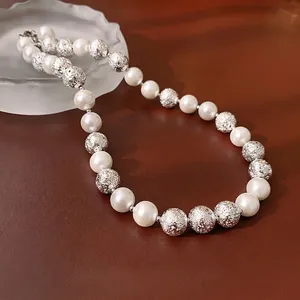 Elegant pearl necklace with silver textured beads on luxury brown leather background