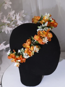 Close-up of orange and white faux flowers on a headpiece for bridal or festival wear