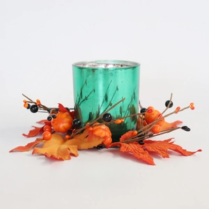 Green glass candle holder with autumn wreath featuring maple leaves and pumpkins