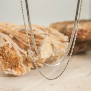 Close-up of minimalist silver stainless steel snake chain and twisted rope necklaces