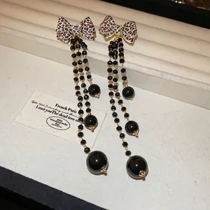 Long leopard print bow tassel earrings with gold chains and black beads for women