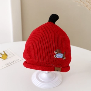 Détail du bonnet tricoté rouge pour bébé avec texture épaisse et broderie chiot