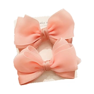 Pair of cute pink organza bow hair clips for baby girls on white display card