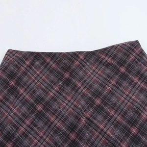 Détail de la texture du tissu à carreaux rouge et gris sur une jupe sirène en tulle