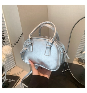 Detailed shot of metallic silver wrinkled texture handbag with round dual handles
