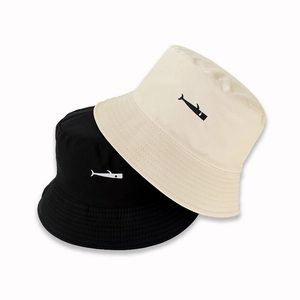 Detail of whale embroidery on black and beige reversible canvas bucket hats