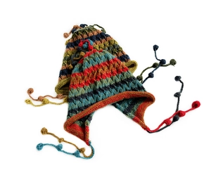 Detailed view of colorful handmade knit beanies with earflaps and tassels on white background