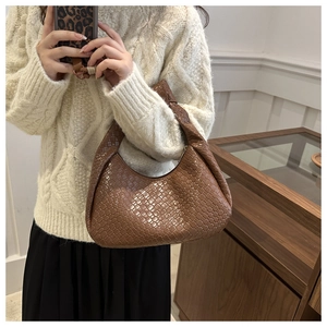 Close-up of brown woven leather hobo bag with distinctive knot handle detail