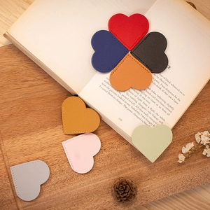 Macro detail of heart-shaped leather bookmarks with stitching on a book corner