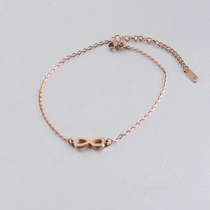 Detailopname van roségouden infinity-armband met karabijnsluiting op een ondergrond