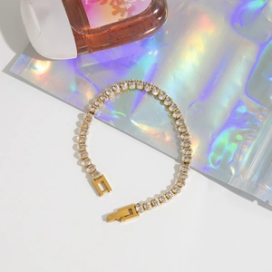 Dettaglio macro del bracciale tennis dorato con zirconi bianchi dal taglio ovale