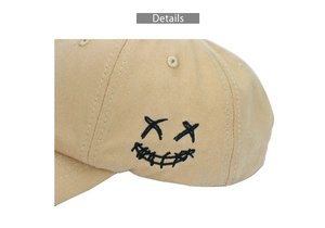 Nahaufnahme der schwarzen Smiley-Stickerei auf der beigen Baumwoll-Baseballkappe