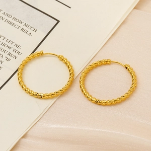 Close-up of golden twist hoop earrings with classic spiral texture and buckle closure