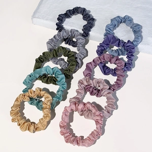 Set of multi-colored satin hair scrunchies in elegant Morandi tones on white background