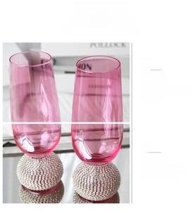 Gros plan d'un verre à vin rose avec une base sphérique luxueuse sertie de strass à la main