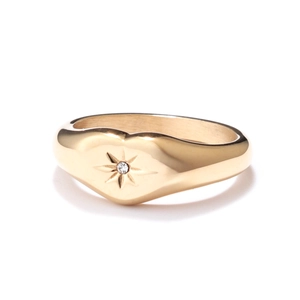 Gold heart signet ring with engraved starburst and diamond center on white background