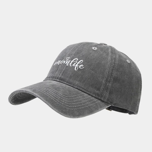 Close-up of washed gray cotton baseball cap featuring white #momlife heart embroidery