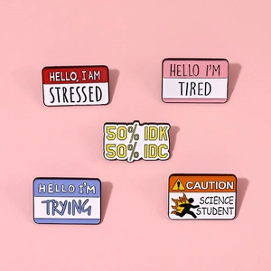 Set of five colorful enamel metal pins with humorous quotes on a soft pink background