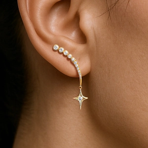 Golden star-shaped crawler earrings featuring sparkling cubic zirconia and drop pendants