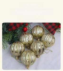 Close-up of red and white Christmas ornaments with gold glitter stripes and hanging cords